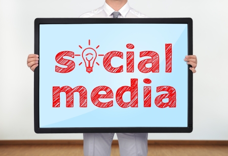 businessman holding a plasma with social mediaの写真素材