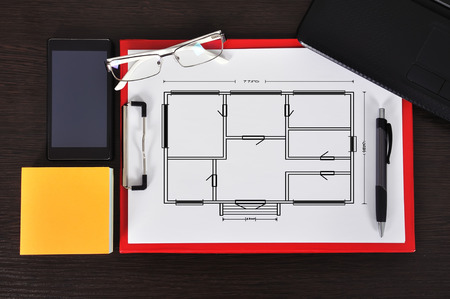 clipboard with drawing blueprint on table and business objectの写真素材