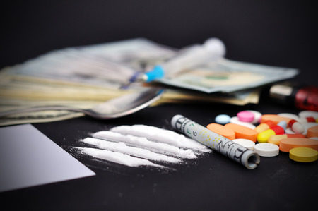 lines of heroin beside a wrapped up dollar bill and narcotic pillsの写真素材