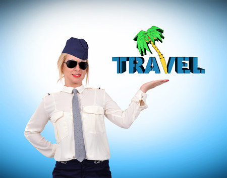 stewardess in uniform holding travel symbol on blue backgroundの写真素材