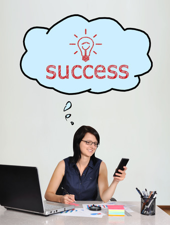 happy businesswoman sitting in office thinking on successの写真素材