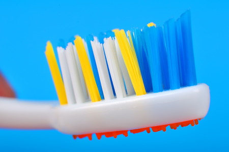 colored toothbrush isolated on a blue backgroundの写真素材