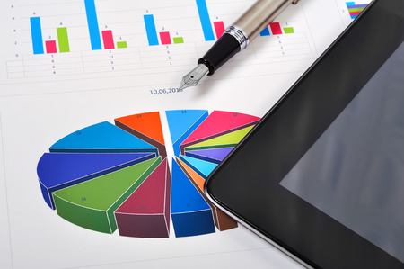 workplace with tablet, charts and ink penの写真素材