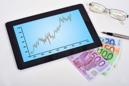 touch pad with chart and euro money on workplaceの写真素材