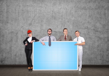 businesspeople in room holding blank plasma panelの写真素材