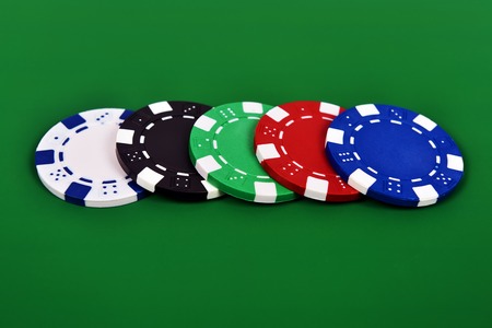 four poker chips on a green background