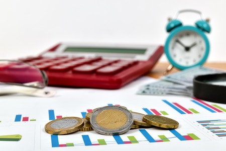 stack of euro coins on stock chart, close up