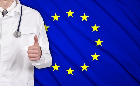 doctor showing thumb up on a EU flag on backgroundの写真素材