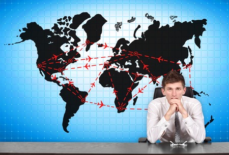 businessman sitting at conference table and air travel scheme on screenの写真素材