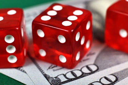 three red casino dices on dollars bill