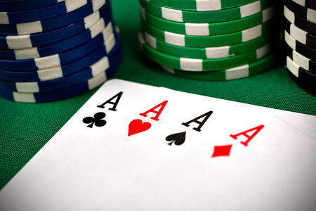 Four aces, including spades, hearts, clubs and diamonds on green table