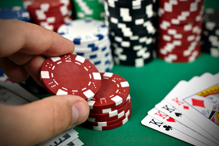 hand holding two color poker chips, close up