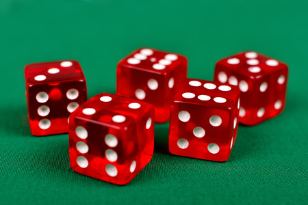 red dice on green table, close up