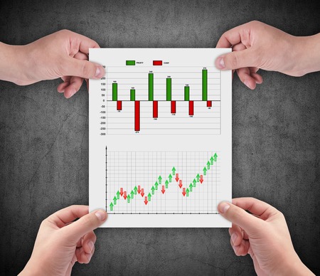 hands holding paper with drawing stock chart
