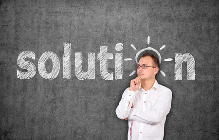 businessman thinking and drawing solution symbol on concrete wallの写真素材
