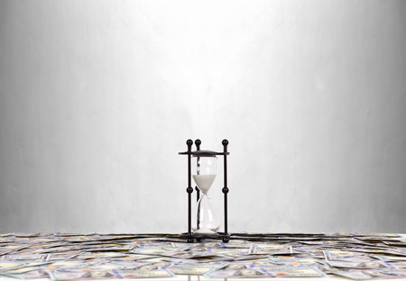 Black hourglass and many dollar banknotesの写真素材