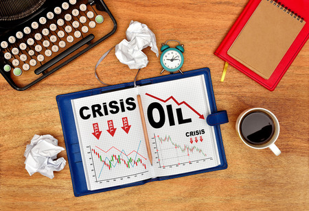 Retro vintage typewriter, pencil, cup and notebook with drawing crisis chart on pageの写真素材