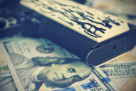 Gun grip and dollar bills. Vintage effectの写真素材