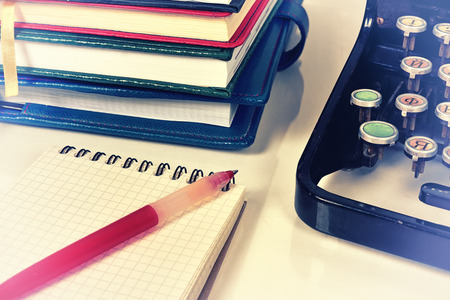 blank note book with red pen and vintage typewriter on table. 
Vintage effectの写真素材