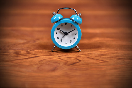 blue alarm clock on brown wooden table