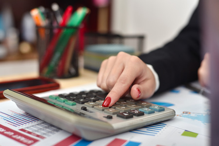 accountant woman considers on the calculator profit close upの写真素材