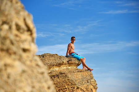 male climber resting on yellow rock after climbingの写真素材