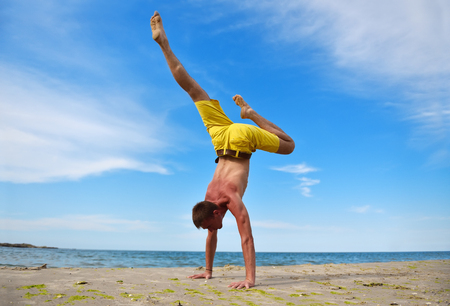 yoga man standing on hands and does the splitsの写真素材