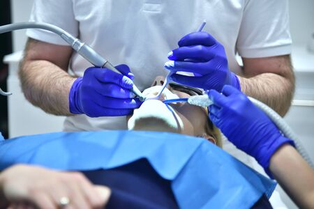 Dentist In Uniform Perform Dental Implantation Operation On Patient At Dentistry Clinic.