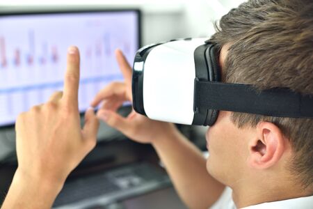 Young Businessman With VR Headset Working On a Virtual Business Report. Interactive Business Working...