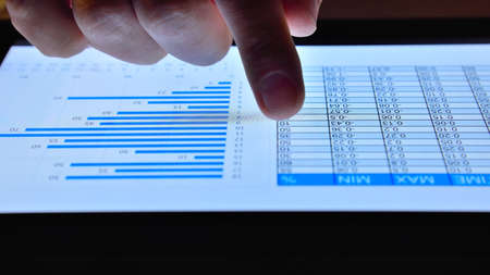 Hand of trader scans on digital tablet online stock market. Business and financial success concept....