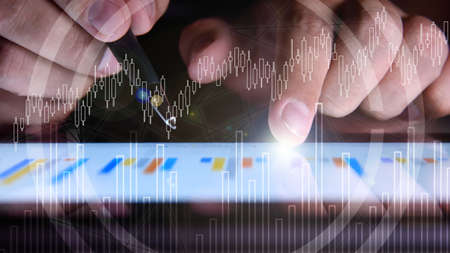 Businessman hand using digital tablet with stock market report interface. Finance snd trade concept....