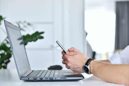 Stock broker man using mobile phone and checks report data. Finance and trade concept. Close up
