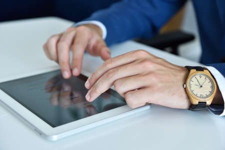 Businessman hand using digital tablet computer to work with financial data. Business and management concept. Close upの写真素材
