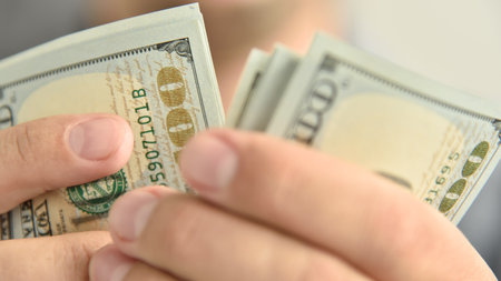 Close up of businessman with dollars money in hands. Financial success and wealth concept.