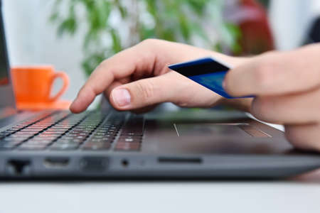 Man hands using laptop and holding credit card. Online payment and shopping concept. Close upの写真素材