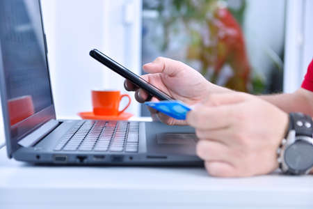 Businessman hands using smarthone and holding credit card. Online payment and  shopping concept. Close upの写真素材
