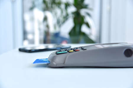 Payment terminal with credit card on table. Payment with credit card on pos terminal. Close Up