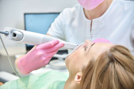Orthodontist scanning teeth with 3d scanning machine. Modern dentistry and health care concept. Close upの写真素材