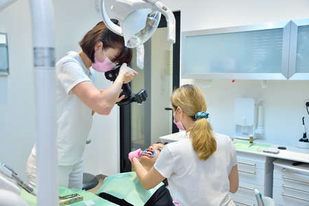 Dentist taking pictures of teeth before teeth whitening procedure. Dental And Teeth Whitening Concept.の写真素材