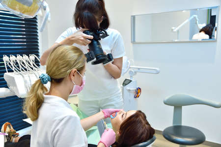 Woman dentist taking pictures of teeth before teeth whitening procedure. Dental and teeth whiteningの写真素材