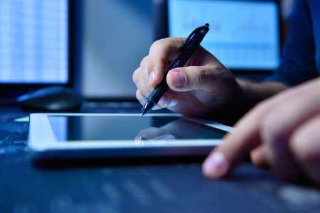 Businessman hands with pen using digital tablet. Global business and information communication technology conceptの写真素材