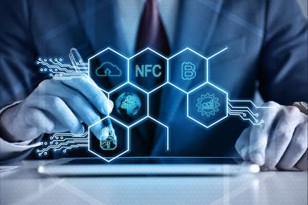 Businessman hands using tablet computer and virtual hexagons hologram with digital business icons....