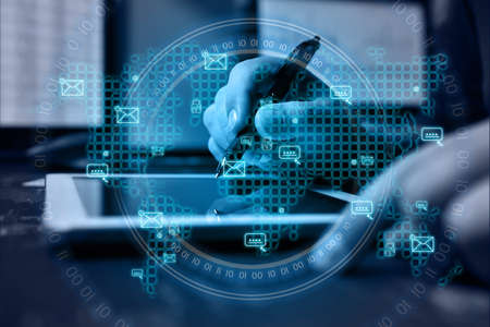 Businessman using tablet computer with envelope icon on a world map interface. Global business and information technology conceptの写真素材