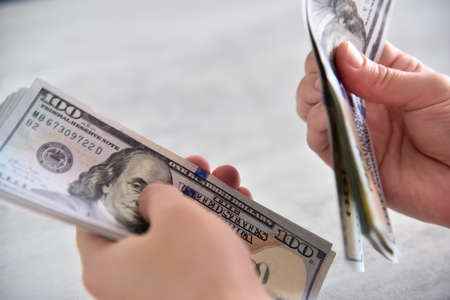 Business woman hands count dollars on table. Corruption and bribery concept. close up