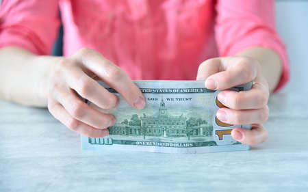 Businesswoman hands holding US dollars cash in office. Financial success and business concept. close upの写真素材
