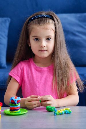 Cute little girl playing with plasticine at home, indoor shootの写真素材