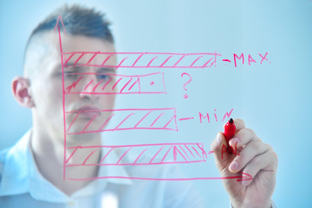Man drawing bar graphs with red marker on transparent glass board, focusing on analysis and data, on a light blue background. Concept of business analysis and data visualizationの写真素材