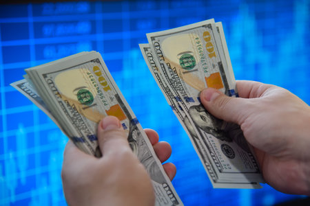 Hands holding and counting us dollar bills. Finance and investments concept. Close upの写真素材