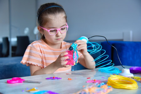 Girl plays with 3D pen. The girl creates 3D toy. Creativity and innovation in art concept.の写真素材