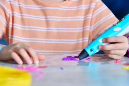 Hands holding 3D pen to create children's toy. Creativity and innovation in art concept. Close up